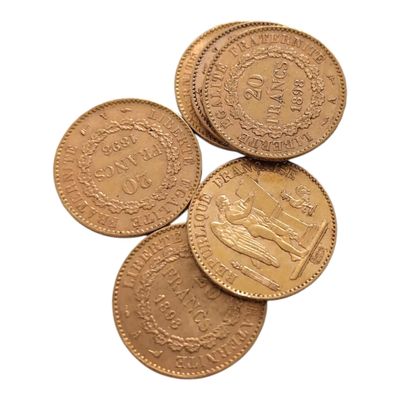 quatre pièces d'or superposées sur une surface blanche