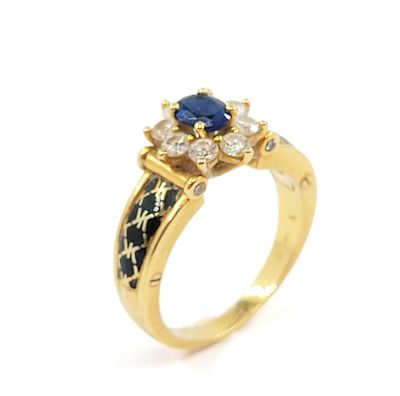 a close up of a gold ring with a sapphire and diamonds