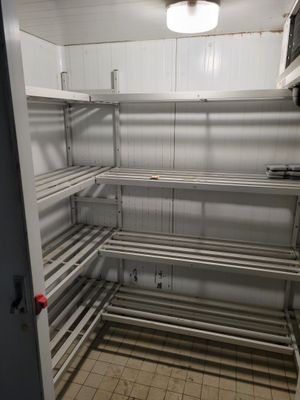 une très longue étagère métallique dans un coin de la pièce