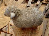 un mouton assis sur une table en bois