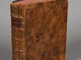 an old book sitting on top of a table next to a gray background