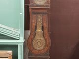 une horloge de parquet posée dans un coin d'une pièce