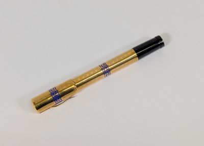 un gros plan d'un stylo noir et doré posé sur une surface blanche
