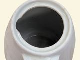 a white vase that has a hole in the middle of it