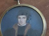 a miniature picture of a man in a black coat