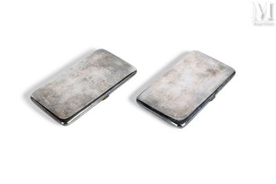 une paire de porte-cartes de visite en métal argenté posés sur un fond blanc