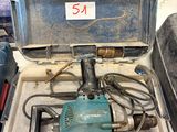 une boîte sur laquelle est posée une perceuse, dans un garage