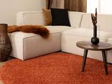 un salon avec un canapé blanc et un tapis rouge