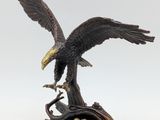 statue représentant un aigle perché sur une branche d'arbre, les ailes déployées