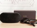 sunglasses and case on a table with a wallpapered wall in the background