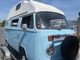 une camionnette bleue au toit blanc garée sur une remorque