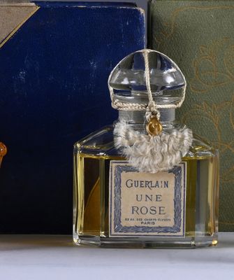 a bottle of perfume sitting on a table next to a book