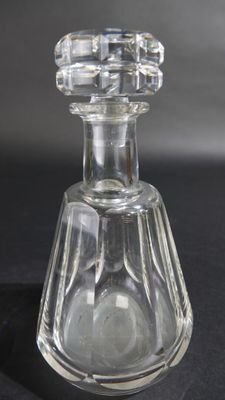 une bouteille en verre transparent avec un bouchon transparent posée sur une surface noire