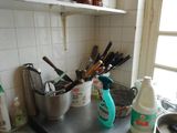 Il y a de nombreux ustensiles de cuisine sur le plan de travail de cette cuisine
