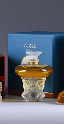 two bottles of perfume sitting next to each other on a table