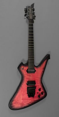 un gros plan d'une guitare électrique rouge sur fond gris
