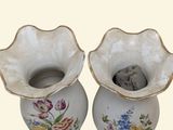 two vases with flowers painted on them on a table