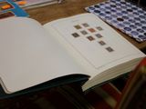 un livre ouvert posé sur une table, avec de nombreux papiers à côté