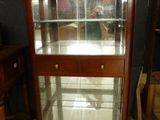 a display case with glass doors in the corner of a room