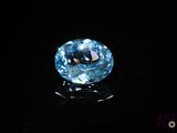 a close up of a blue diamond on a black surface