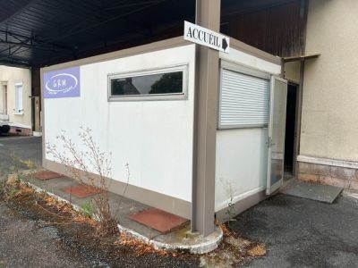 un petit bâtiment blanc avec une enseigne sur le côté