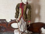 a figurine of a man sitting on a bench with a cane