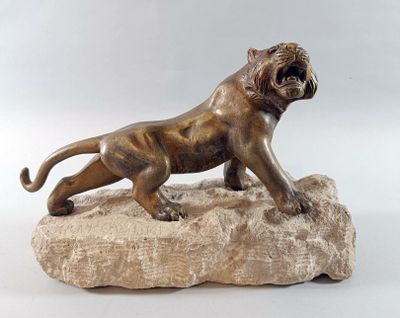 bronze statue of a lion on a rock on a white background