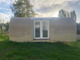 une photo d'une petite maison au milieu d'un champ