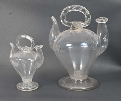 two glass vases sitting next to each other on a table