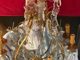 a gold chandelier with a dress on top of it