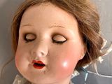a close up of a doll with a red lip