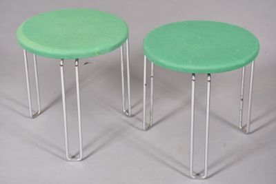 pair of green stools with metal legs on a white surface