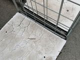 a metal cage with a white tile on the floor