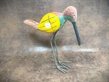 a bird that is standing on the ground with a stick in it ' s beak