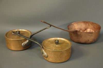 three pots and pans sitting on a table