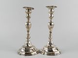 a pair of silver candlesticks on a white background