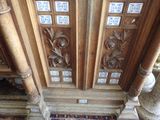 des sculptures au plafond d'une pièce dont le sol est recouvert d'un tapis