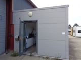 a small building with a door open in a parking lot