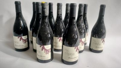 six bottles of wine are lined up in a row on a white surface