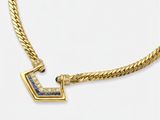 un collier en or jaune orné d'un pendentif en diamants bleus et blancs