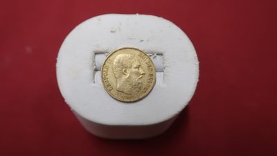 gros plan d'une pièce d'or sur une surface rouge