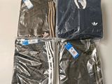 three pairs of adidas t - shirts in plastic bags on a table