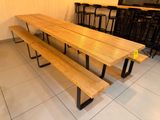une table en bois avec deux bancs au milieu de la pièce