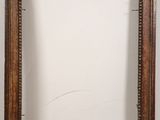 an old wooden picture frame with a white wall in the background