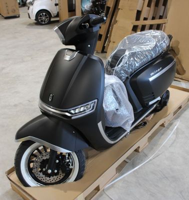 un scooter posé sur un chariot dans un entrepôt