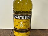 a bottle of chartreuse sitting on a wooden table