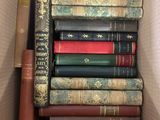 many books in a box that are stacked together