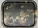 a black tray with a painting on it on a table