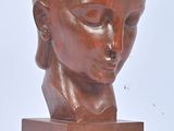 sculpture of a woman ' s head on a wooden base