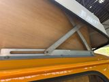 a close up of a yellow van with a surfboard on top of it